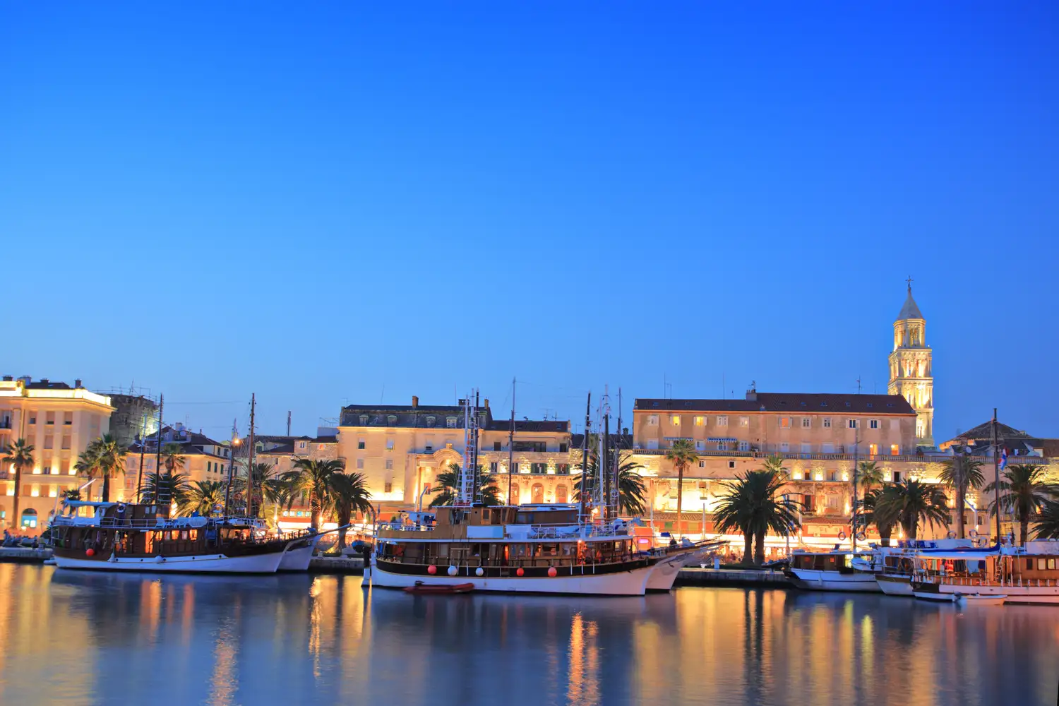 Mediterranean coastal town with red-tiled roofs and a harbor full of boats